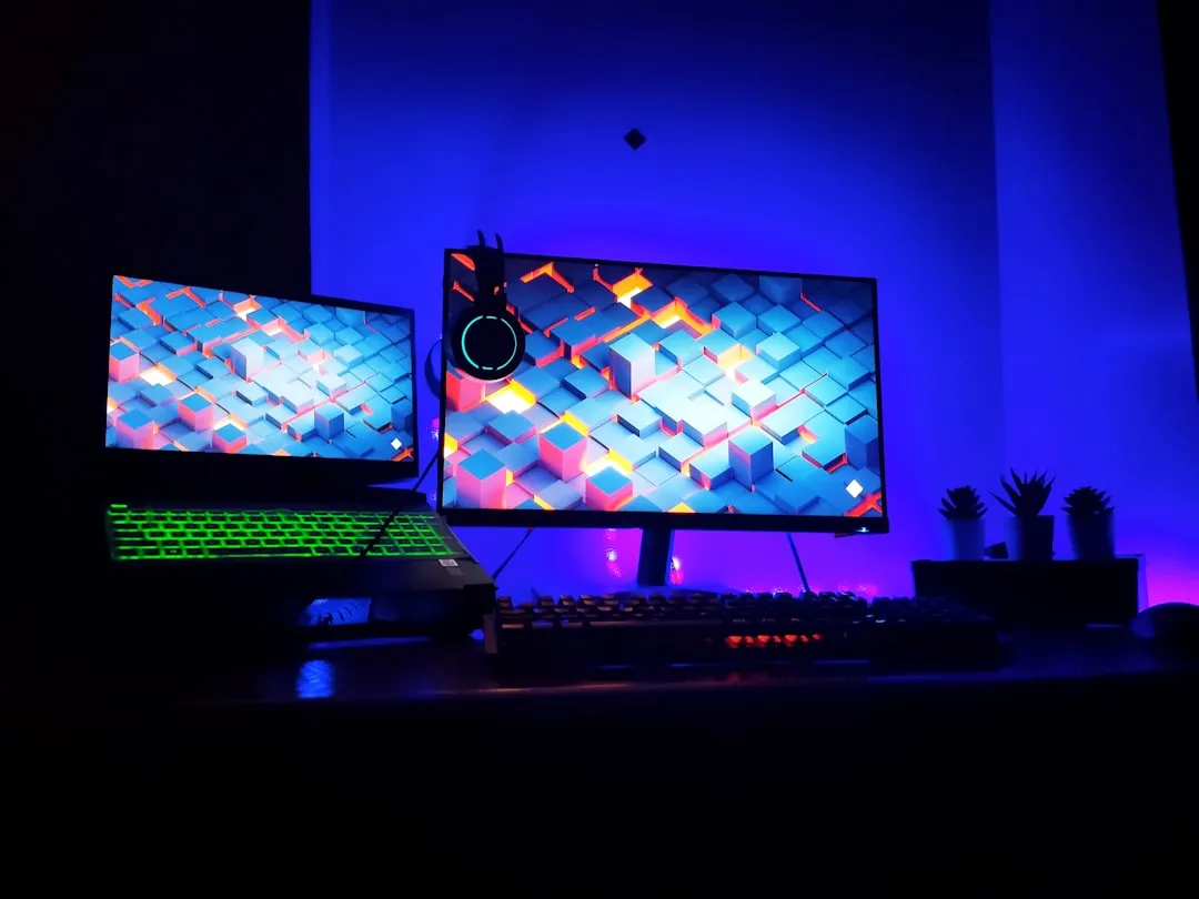 High-tech gaming battlestation, dual monitors, RGB-backlit keyboard, mouse on a stand, blue ambient lighting, photo by amjed omaf on Unsplash