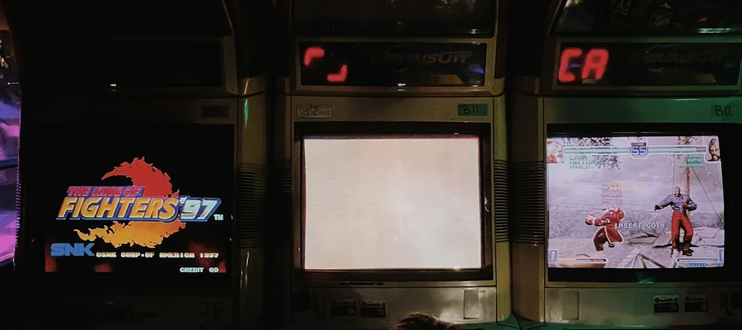 Dimly lit row of vintage arcade cabinets, image selected 2026-07-15